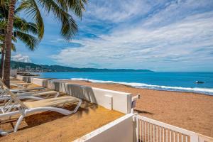 a beach with chaise lounge chairs and the ocean at Harbor 171 Oceanfront Residences #13011 in Puerto Vallarta
