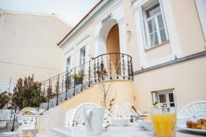 a table with plates of food and orange juice at Archontiko Eleni Hotel in Andros