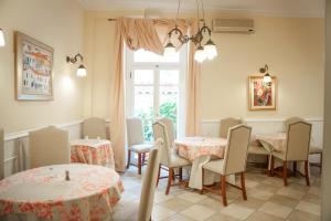 a dining room with tables and chairs and a window at Archontiko Eleni Hotel in Andros