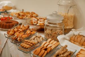 a table filled with different types of pastries and cookies at Archontiko Eleni Hotel in Andros