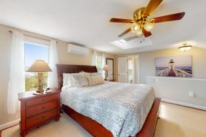 1 dormitorio con 1 cama y ventilador de techo en Sunset Cove Retreat, en Wareham