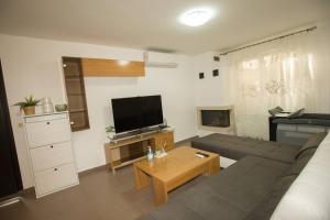 a living room with a couch and a flat screen tv at My Greko Home in Neoi Epivates