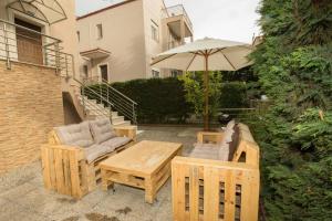 a patio with a table and chairs and an umbrella at My Greko Home in Neoi Epivates