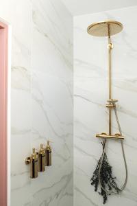 een badkamer met een gouden lamp en een marmeren muur bij Bed & Bakkie Het Lamsoor Texel in 't Horntje