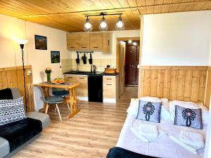 a living room with a couch and a kitchen at Mały Bystry Domek in Kościelisko