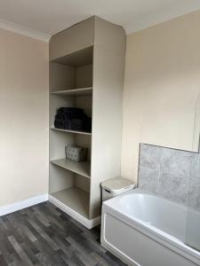 a white bathroom with a tub and a sink at Cosy house in Wombwell in Barnsley