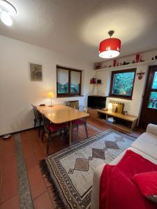 uma sala de estar com uma mesa e um sofá em casa nel bosco cir vda 0192 em Courmayeur