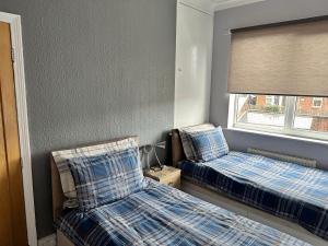 a bedroom with two beds and a window at Cosy house in Wombwell in Barnsley