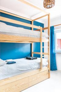 2 łóżka piętrowe w pokoju z niebieską ścianą w obiekcie Surf Yoga Ericeira Guest House w mieście Ericeira