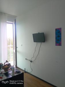 a room with a tv on a white wall at Апартамент Тита in Burgas