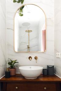 een badkamer met een witte wastafel en een spiegel bij Bed & Bakkie Het Lamsoor Texel in 't Horntje
