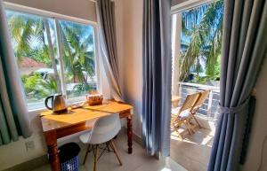 Zimmer mit einem Tisch und 2 großen Fenstern in der Unterkunft Lucky Spot Beach Bungalow in Song Cau