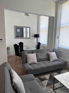 een woonkamer met een bank en een tafel bij NEW HMM Apartmentz - Free parking - Beautiful area in Sunderland