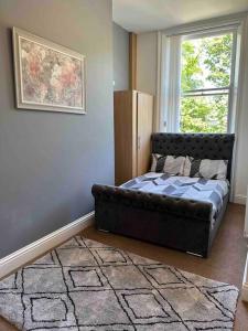 um quarto com um sofá de couro e uma janela em NEW HMM Apartmentz - Free parking - Beautiful area em Sunderland