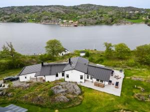 an aerial view of a house on the shore of a lake at Exclusive house with private boathouse in Nösund