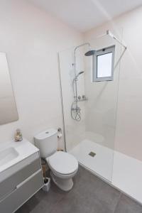 a white bathroom with a toilet and a shower at Nascer Do Sol Retreat Villa in Conceição