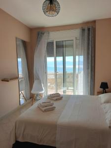 una camera da letto con un grande letto con una grande finestra di Antea Apartment 3 a Vlorë