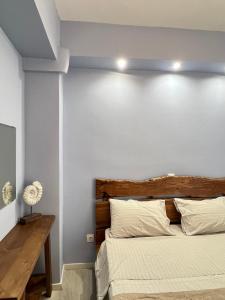 a bedroom with a bed with a wooden headboard at Sunny Seaside Cozy Home in Piraeus
