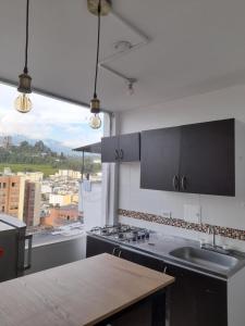 a kitchen with a sink and a counter top at Casa Colibrí Hospedaje Manizales a 2 min del Cable y 1 min Zona G in Manizales