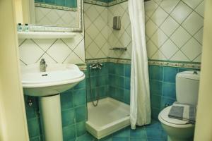 a bathroom with a sink and a toilet and a shower at Archontiko Eleni Hotel in Andros