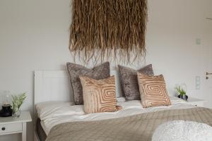 uma cama com almofadas num quarto em Exclusive house with private boathouse em Nösund