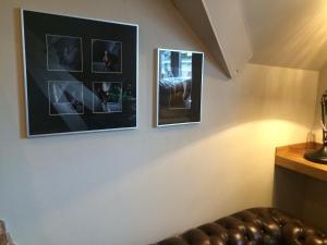 two pictures hanging on a wall with a leather couch at Boutique hotel Box 5 in Nijmegen
