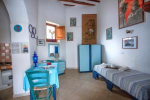 Habitación con cama, mesa y armario azul. en Case Vacanza Gia.no, en Stromboli