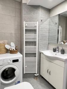 a bathroom with a washing machine and a sink at Sunny Seaside Cozy Home in Piraeus