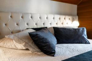 a bed with two black pillows on it at Hotel Kehl Haus in Gramado