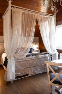 sypialnia z łóżkiem z baldachimem i zasłonami w obiekcie Hotel Kehl Haus w mieście Gramado