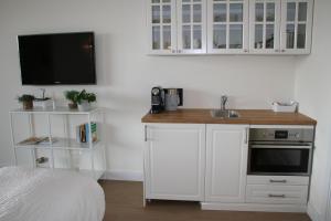 a white kitchen with a sink and a microwave at Waterfront Studio in Amsterdam