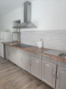 a kitchen with white cabinets and a wooden counter top at Gîte le domaine de Dolly in Villeneuve-sur-Lot