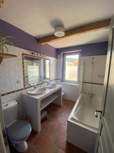 a bathroom with two sinks and a tub and a toilet at Les Volets Bleus in Malaucène +20 photos