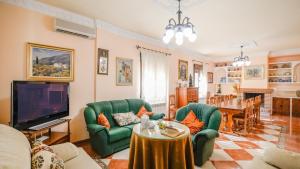 Sala de estar con 2 sillas verdes y TV en HACIENDA LA TOSCANA en Priego de Córdoba