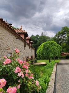un edificio con flores rosas junto a una carretera en Gîte le domaine de Dolly, en Villeneuve-sur-Lot