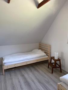 a bedroom with a bed and a table in a attic at Winnica Bracia Petrasz in Lisna