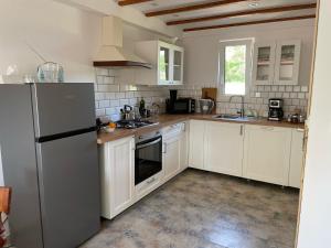 a kitchen with white cabinets and a stainless steel refrigerator at Winnica Bracia Petrasz in Lisna