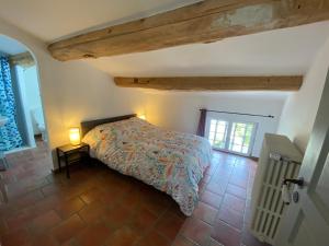 een slaapkamer met een bed in een kamer bij Les Volets Bleus in Malaucène