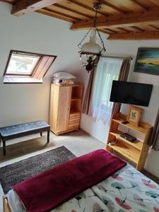 a bedroom with a bed and a flat screen tv at Klára Vendégház in Badacsonyörs