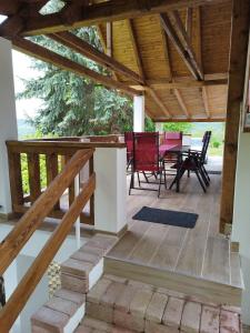 un patio con mesa, sillas y techo de madera. en Klára Vendégház, en Badacsonyörs