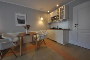 a kitchen with a table and chairs in a room at Ambasador Villa, 150m do plaży, przy Centrum in Mielno