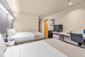una camera d'albergo con 2 letti e una scrivania con un computer di Microtel Inn & Suites by Wyndham Sainte Genevieve a Sainte Genevieve Altre 30 foto