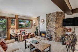 uma sala de estar com uma grande lareira de pedra em Laurelwood Condominiums 109 em Snowmass Village