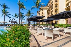an outdoor dining area with tables and umbrellas at a resort at Villa La Estancia Beach Resort & Spa Riviera Nayarit in Nuevo Vallarta 
