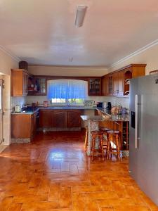 a kitchen with wooden floors and a stainless steel refrigerator at Casa das Laranjeiras in Alqueidão da Serra