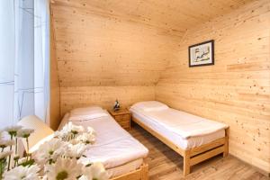 a room with two beds in a sauna at Kolorowe Domki Rewal, 200m do plaży, morza Uwielbiany przez rodziny z dziećmi in Rewal