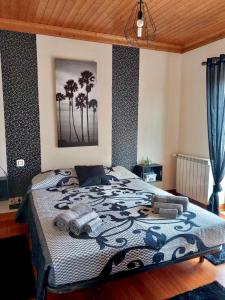 a bedroom with a bed with palm trees on the wall at Casa das Laranjeiras in Alqueidão da Serra