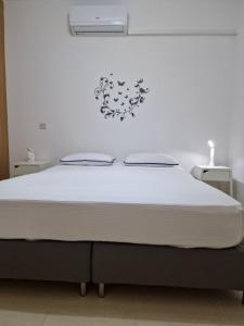 een bed in een slaapkamer met een witte muur bij Cozy ground floor appartment with communal pool in Paralimni