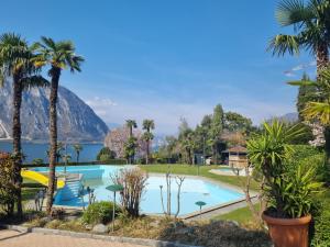 ein Resort mit einem Pool und einem Berg im Hintergrund in der Unterkunft Lake Apartment 4 in Bissone