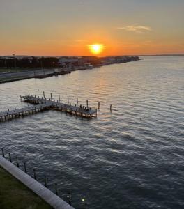 a dock in the water with the sunset in the background at Bay Club Resort in Ocean City